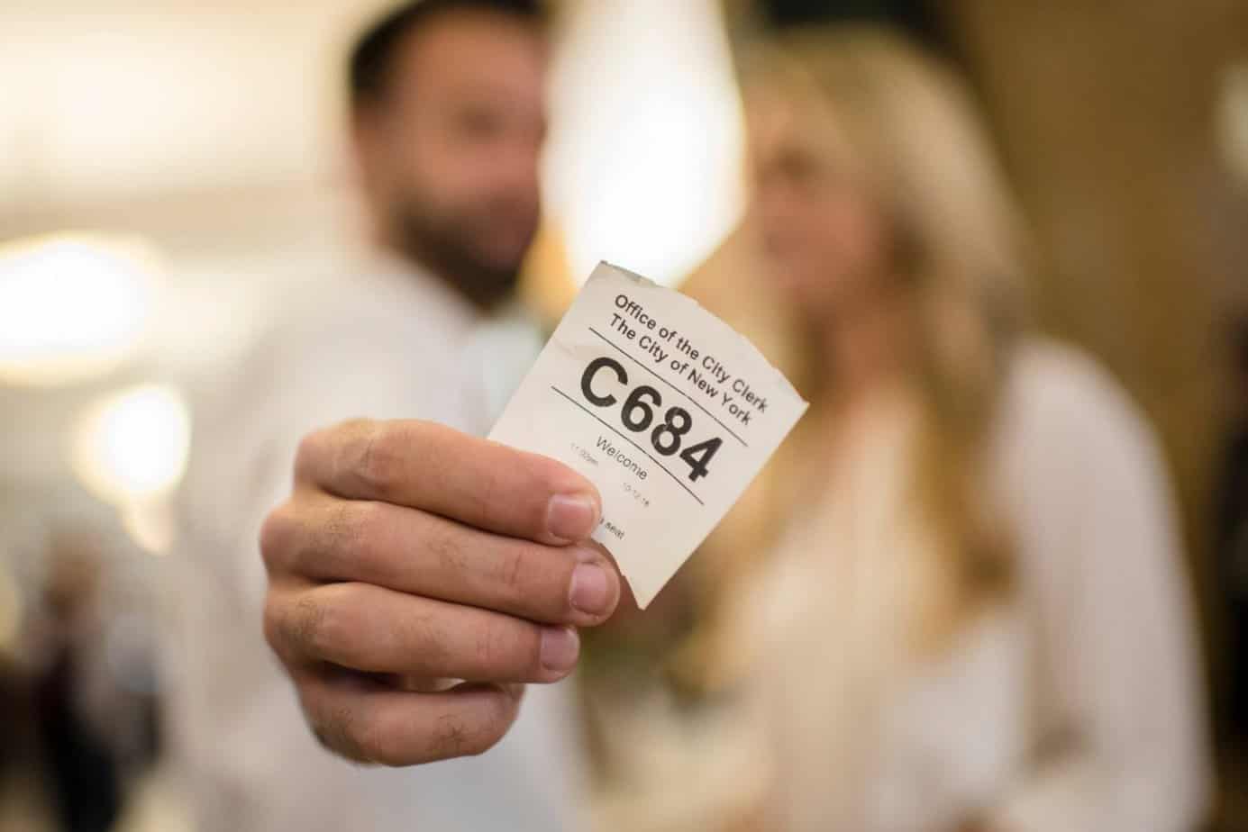 couple holding a marriage ticket at city hall in nyc couple holding a marriage ticket at city hall in nyc