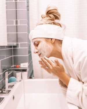 girl washing face at sink