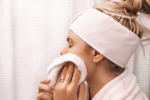 girl drying her face with a towel