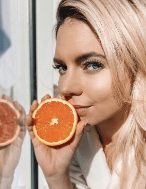 girl holding a sliced orange